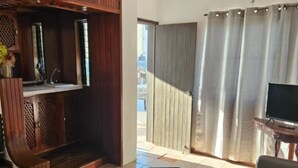 Ein Wohnzimmer mit einer Couch, einem kleinen Tisch, einem Fernseher und einem Deckenventilator.