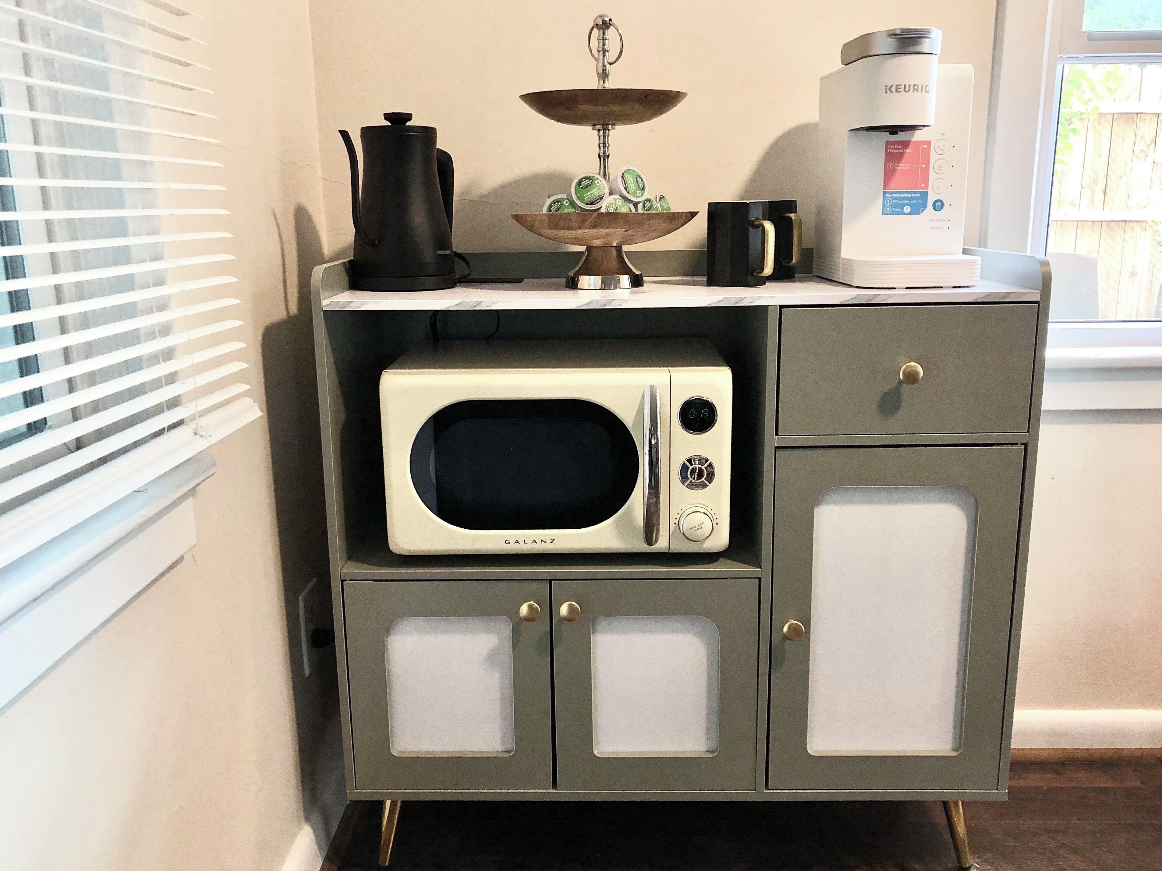 A kitchenette with a microwave, a coffee maker, and a kettle.
