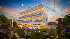 A modern two-story house with a balcony, outdoor seating area, and a swimming pool. - Marathon Sombrero Beach  5 min to Beach, Pool, 70' Dock, Elevator (Marathon)