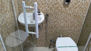 A small bathroom with a toilet, sink, and shower. - POUSADA RENASCER MAGE  (Mage)