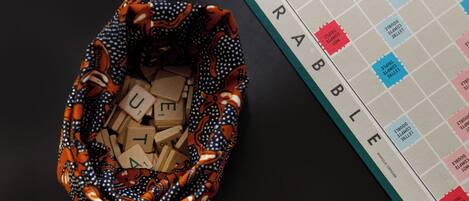 Un juego de Scrabble junto a una bolsa con fichas de letras.