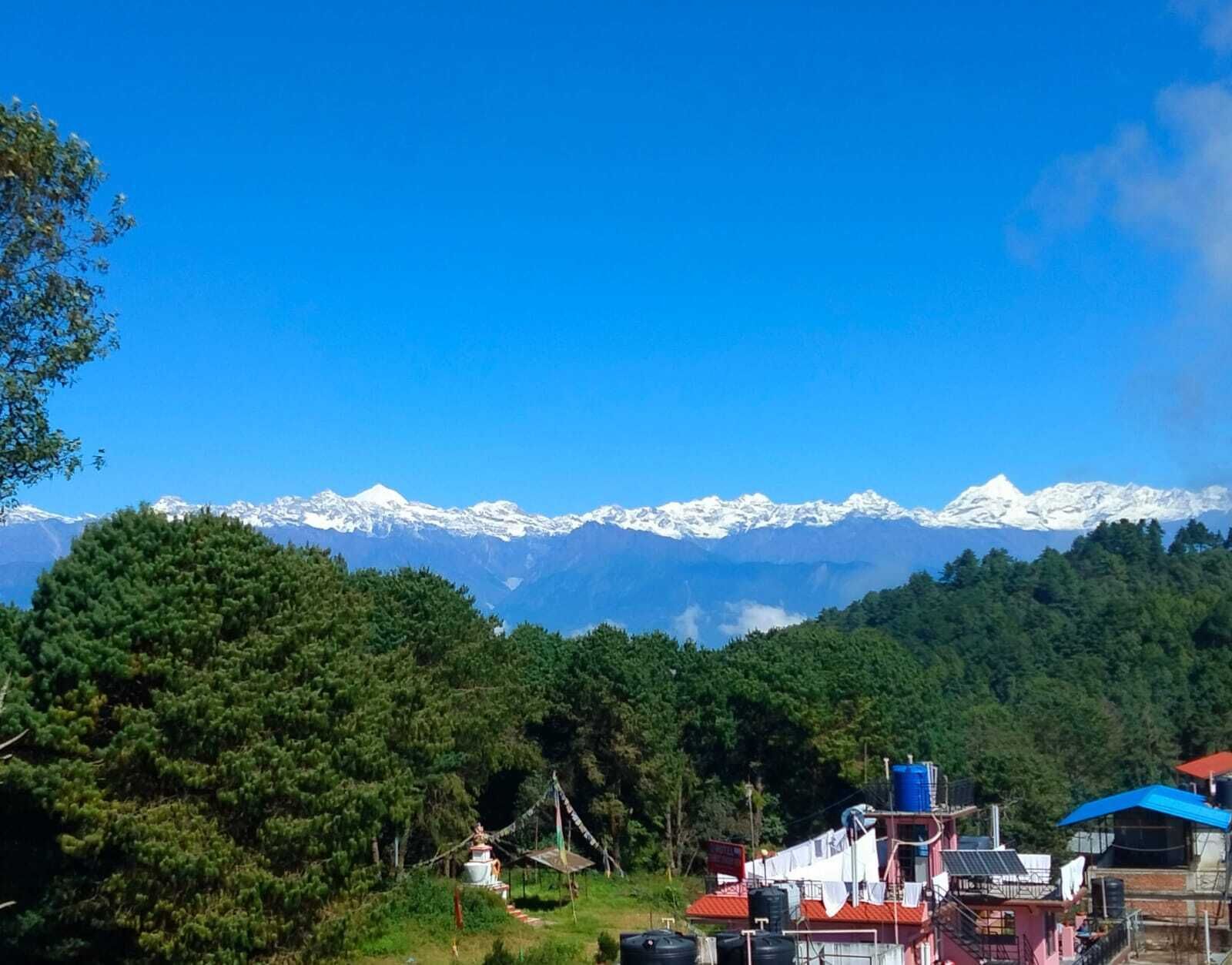Vista de un paisaje montañoso con picos nevados al fondo.