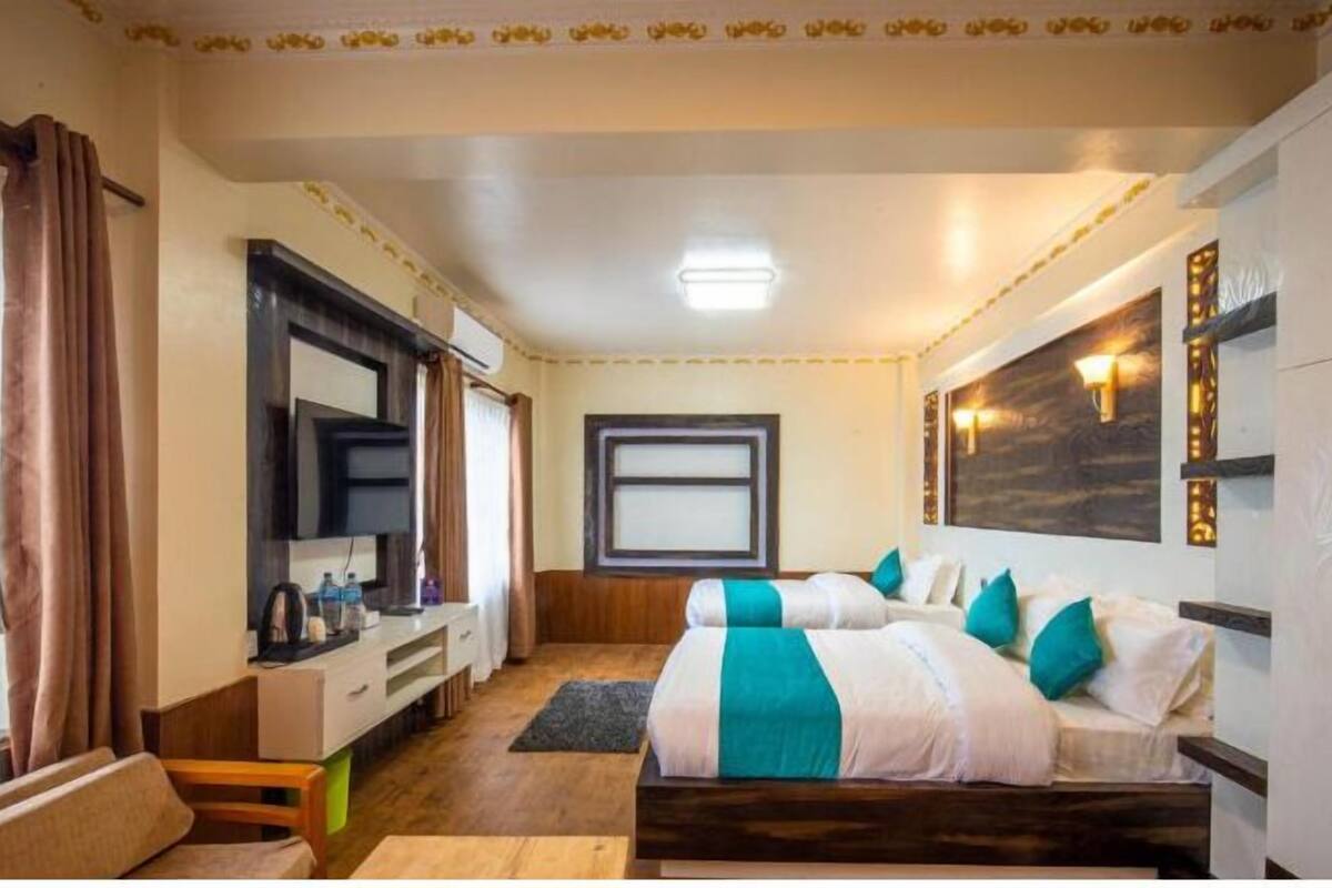 A hotel room with a bed, a desk, a mirror, and a window.