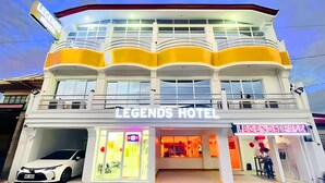 Un hotel con un cartel que dice "Legends Hotel" y una cafetería llamada "Legends Cafe" debajo.
