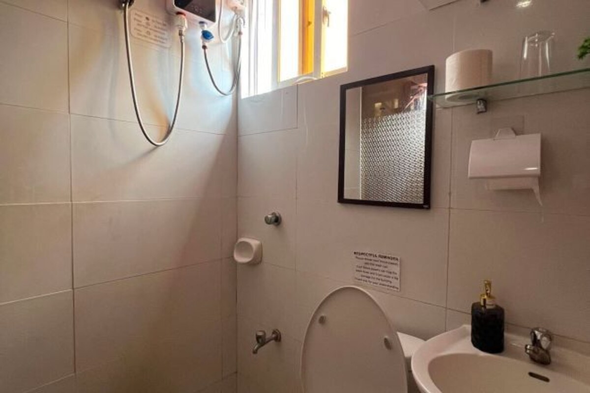 A bathroom with a toilet, sink, and shower.