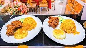 Interior de un restaurante con mesas y sillas, y una exhibición de alimentos en la barra.