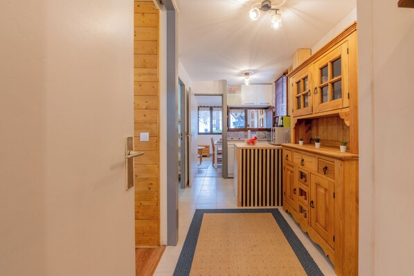 Une cuisine avec des meubles en bois, un îlot central et une vue sur la salle à manger.