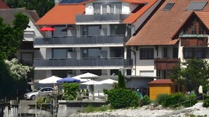A multi-story building with balconies, a swimming pool, and a waterfront view. - Apartment 'Typ A2 2 Obergeschoss Nummer 13' with Shared Terrace, Shared Garden and Wi-Fi (Immenstaad am Bodensee)