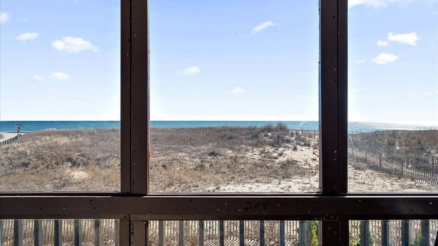 Blick aus einem Fenster auf Strand und Meer.