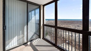 Ein Balkon mit Blick auf Strand und Meer.