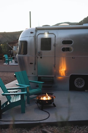 A camper with a fire pit and outdoor seating.