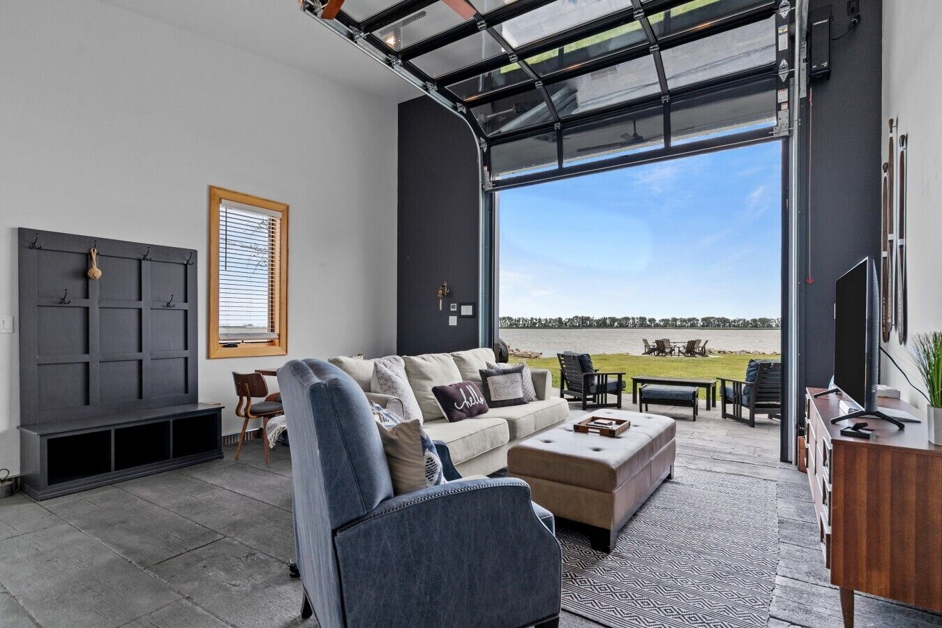 A modern living room with a large window, a sofa, a coffee table, and a TV.