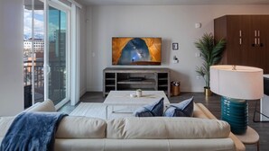 A modern living room with a sofa, coffee table, and a TV on a stand. - Convention Ctr Luxury 1BR Pool Gym Hot Tub (Salt Lake City)