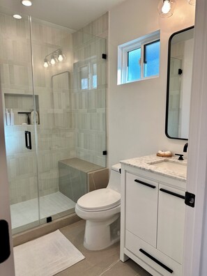 Een douche, handdoeken, zeep, toiletpapier