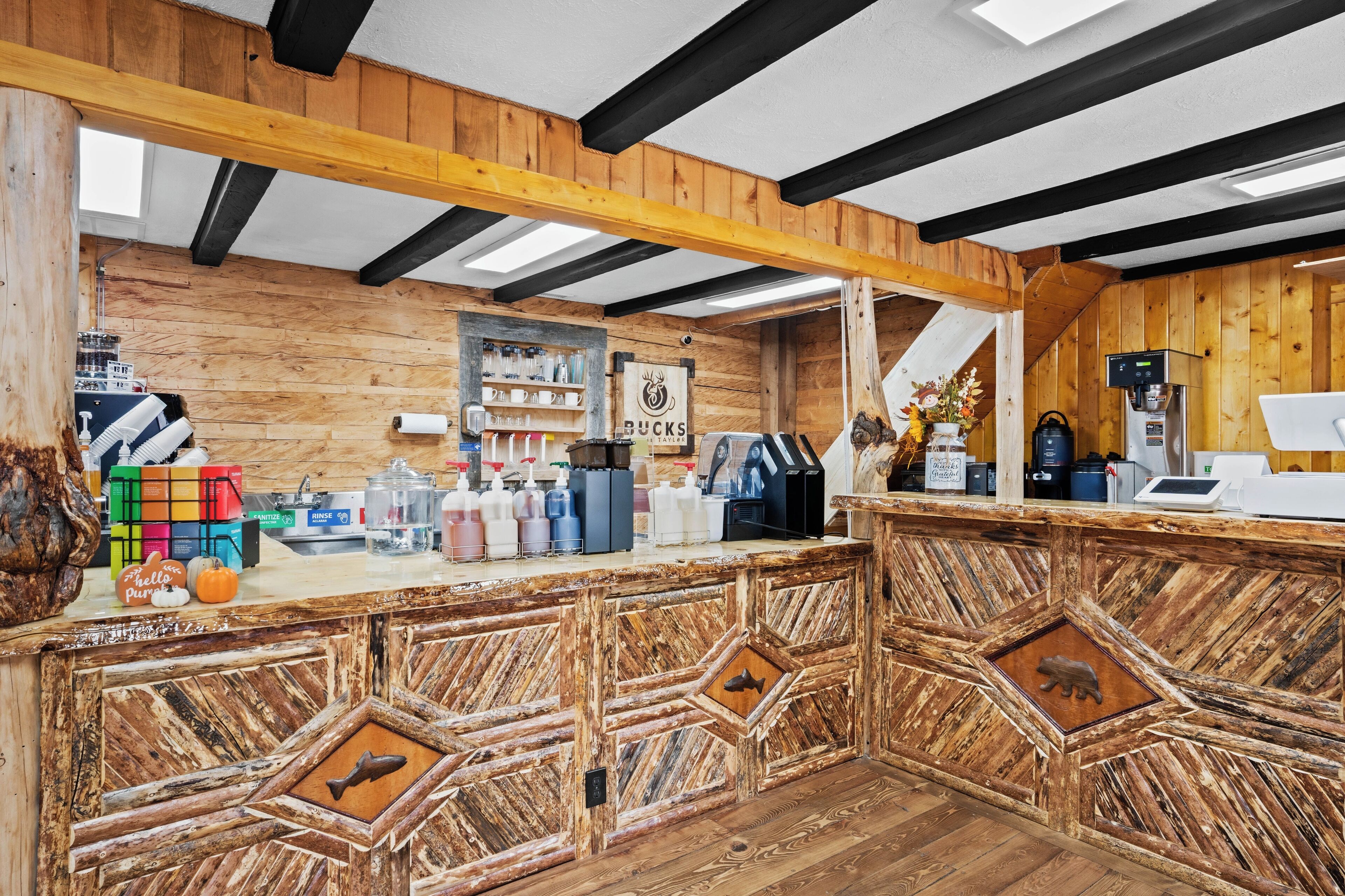 A wooden interior with a bar area, shelves with bottles, and a sign for 'BUCKS'.