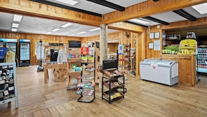 Une boutique au décor rustique, avec des poutres en bois, un tableau noir servant de menu et différents présentoirs de collations.