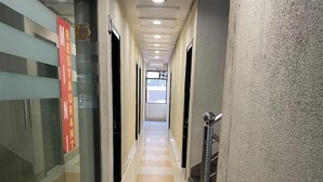 Un couloir avec un sol à motifs de carreaux, des portes vitrées et un panneau indiquant l’emplacement d’un restaurant.