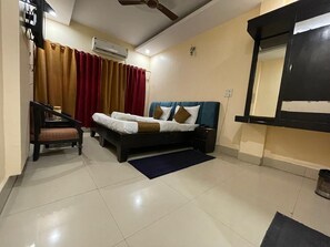 A bedroom with a bed, a chair, a desk, and a wardrobe.