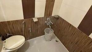 Une petite salle de bain avec des toilettes, une douche et un lavabo.