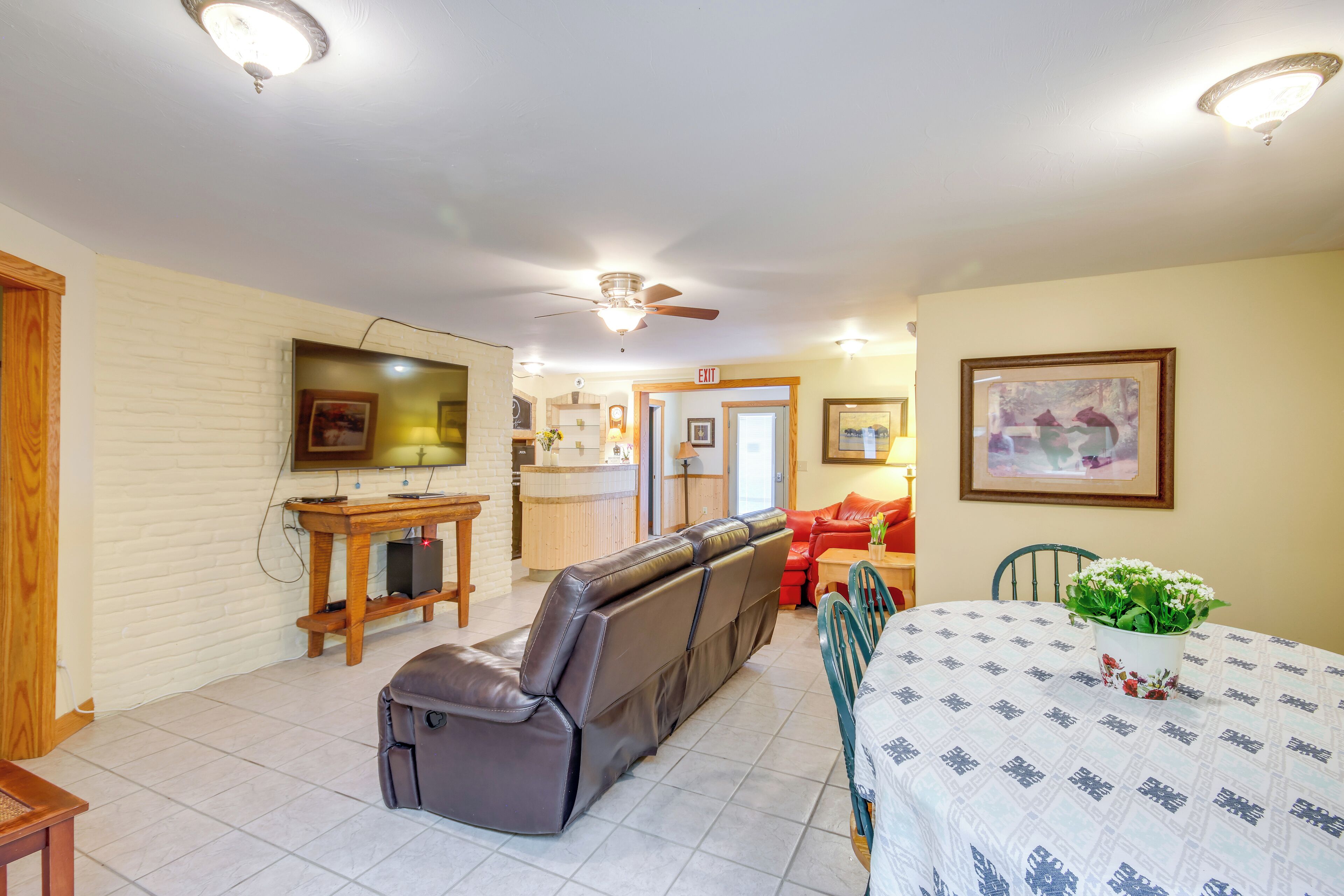 A spacious living area with a sofa, dining table, and a ceiling fan.