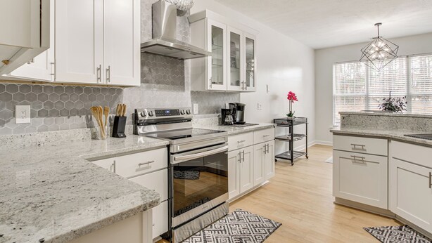 A modern kitchen with white cabinets, a stainless steel range, and a built-in oven. - Tee Off in Augusta: Masters Retreat w/ Patio (Graniteville)
