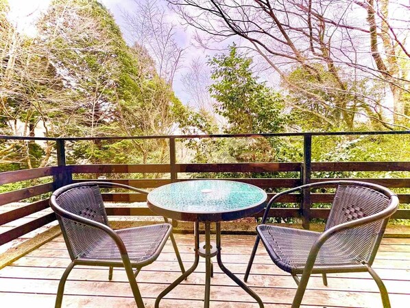 A wooden deck with a round glass table and two wicker chairs. - HAKONE saryo KINTOKI (Hakone)