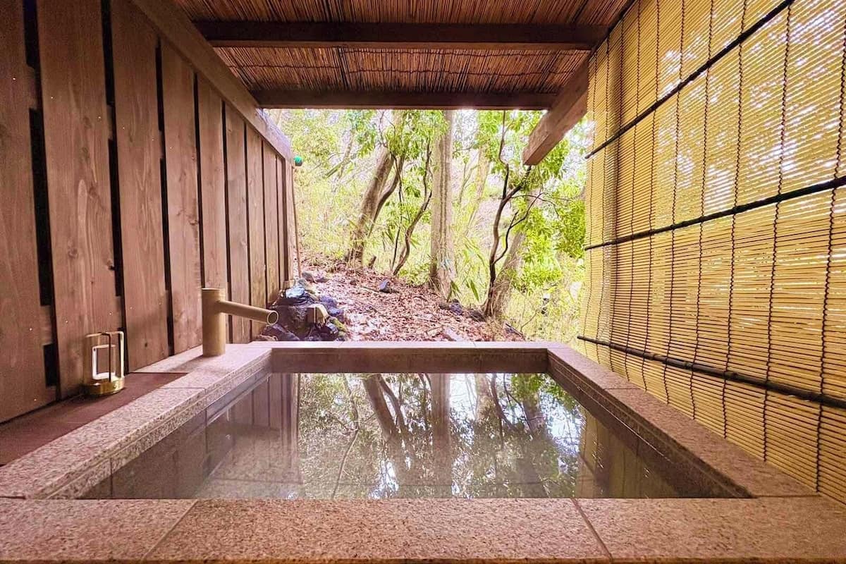 A traditional Japanese onsen with wooden walls and a stone bath.