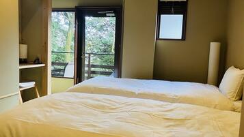 A bedroom with a bed, a desk, and a window.