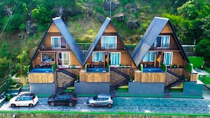 A modern, symmetrical building with a triangular roof, multiple balconies, and a parking area. - Cloub Cabana Holidays (Kanjirappally)