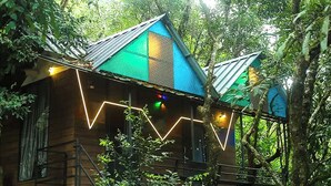 A wooden cabin with a metal roof, surrounded by dense forest. - Cloub Cabana Holidays (Kanjirappally)