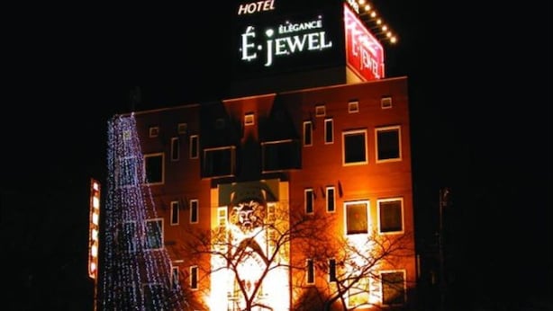 A hotel named "É. JEWEL" with illuminated signage, a prominent entrance, and a Christmas tree decoration.