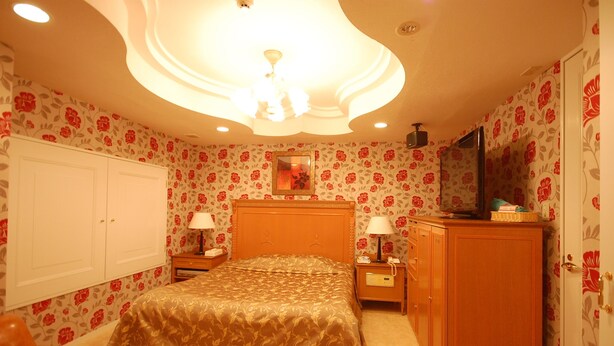 A bedroom with a bed, nightstands, a dresser, and a television. - E-JEWEL (Amagasaki)