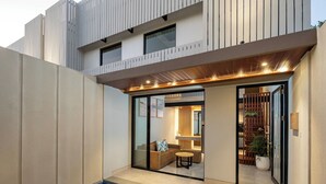 A modern house with a glass door entrance, a small pool, and a wooden deck. - The New Moon Umalas (Kerobokan)