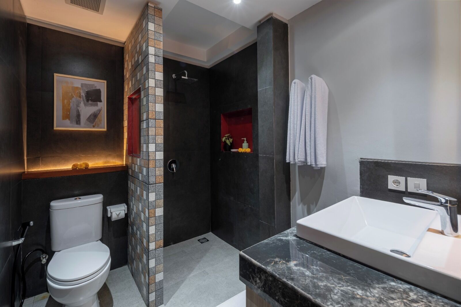 A modern bathroom with a toilet, shower, and sink.