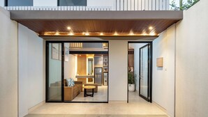 A modern, open-plan living area with a kitchen, a dining area, and a seating space. - The New Moon Umalas (Kerobokan)