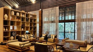Un salón amplio con piso de madera, una gran estantería y cómodos asientos.