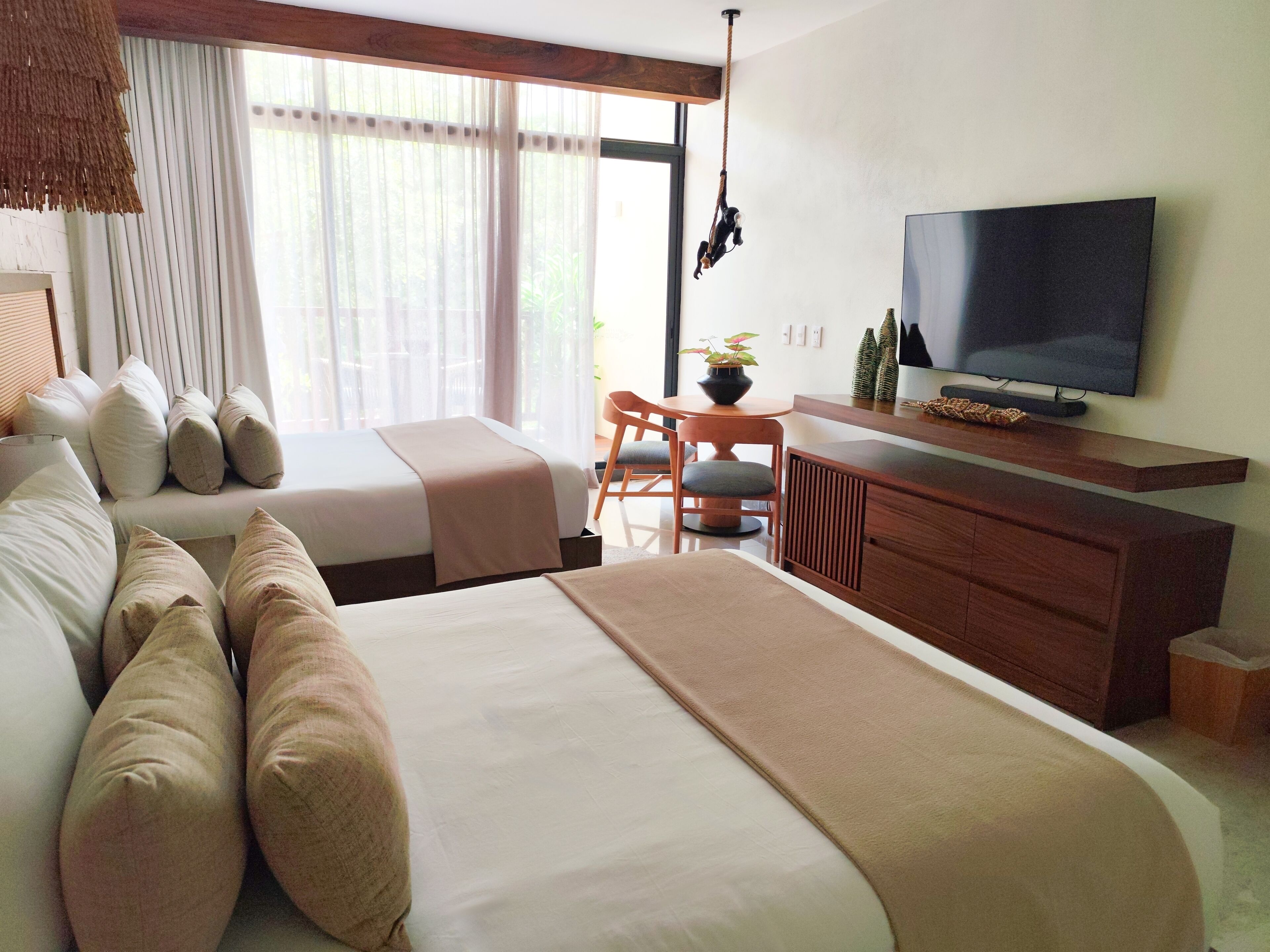 A hotel room with two beds, a TV, a desk, and a chair.