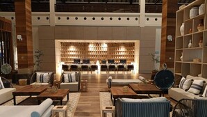 Amplio espacio de exhibición con varias zonas de estar, una pared de exhibición central y una gran variedad de muebles y objetos decorativos.