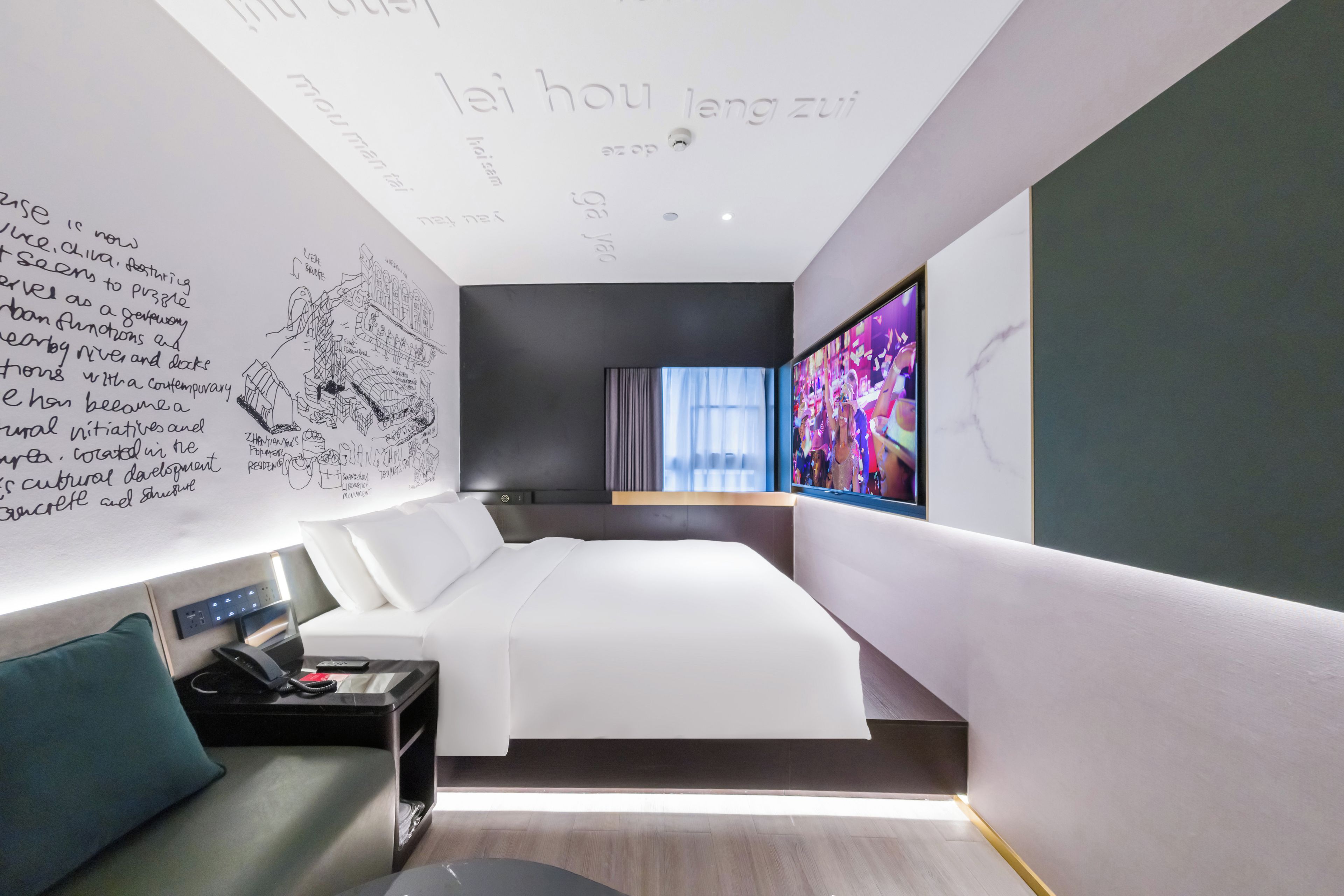 Une chambre d’hôtel moderne avec un grand lit, un bureau et une télévision.