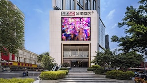 A modern hotel entrance with a large digital billboard above the entrance. - CitiGO Hotel Ouzhuang (Guangzhou)