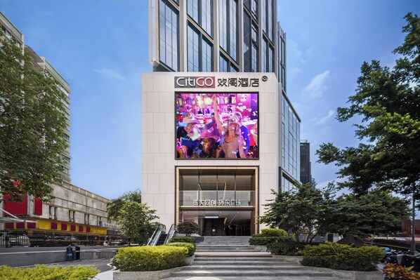 Una entrada de hotel moderna con un gran anuncio digital sobre la puerta.