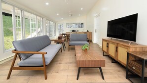 Un salon moderne avec un canapé, une table basse, un téléviseur et un meuble en bois.