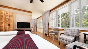 Une chambre d’hôtel avec deux lits, une télévision, un bureau et une chaise.