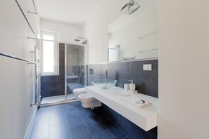Een douche, een haardroger, een bidet, handdoeken