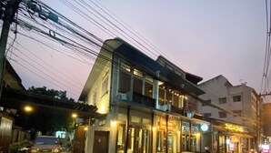 Un edificio de dos pisos con restaurante en la planta baja y viviendas en el nivel superior.