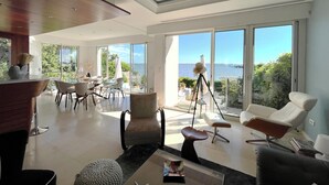 A spacious living area with a large sliding glass door leading to a balcony with a view of the sea. - Bassin front villa with private beach access, heated pool - 14 pers (Andernos-les-Bains)