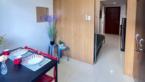 A modern dining area with a black table, red chairs, and a potted plant. - 1 BR Shell Residences Facing amenities (Pasay)