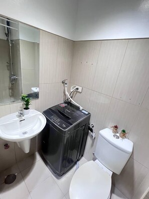 A bathroom with a sink, toilet, and a water heater. - 1 BR Shell Residences Facing amenities (Pasay)