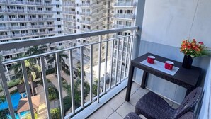 A balcony with a view of a swimming pool and high-rise buildings. - 1 BR Shell Residences Facing amenities (Pasay)