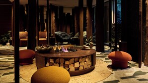 A modern interior with a central fire feature, seating areas, and a stone wall. - GLAMDAYSTYLE HOTEL&RESORT KYU-KARUIZAWA (Karuizawa)